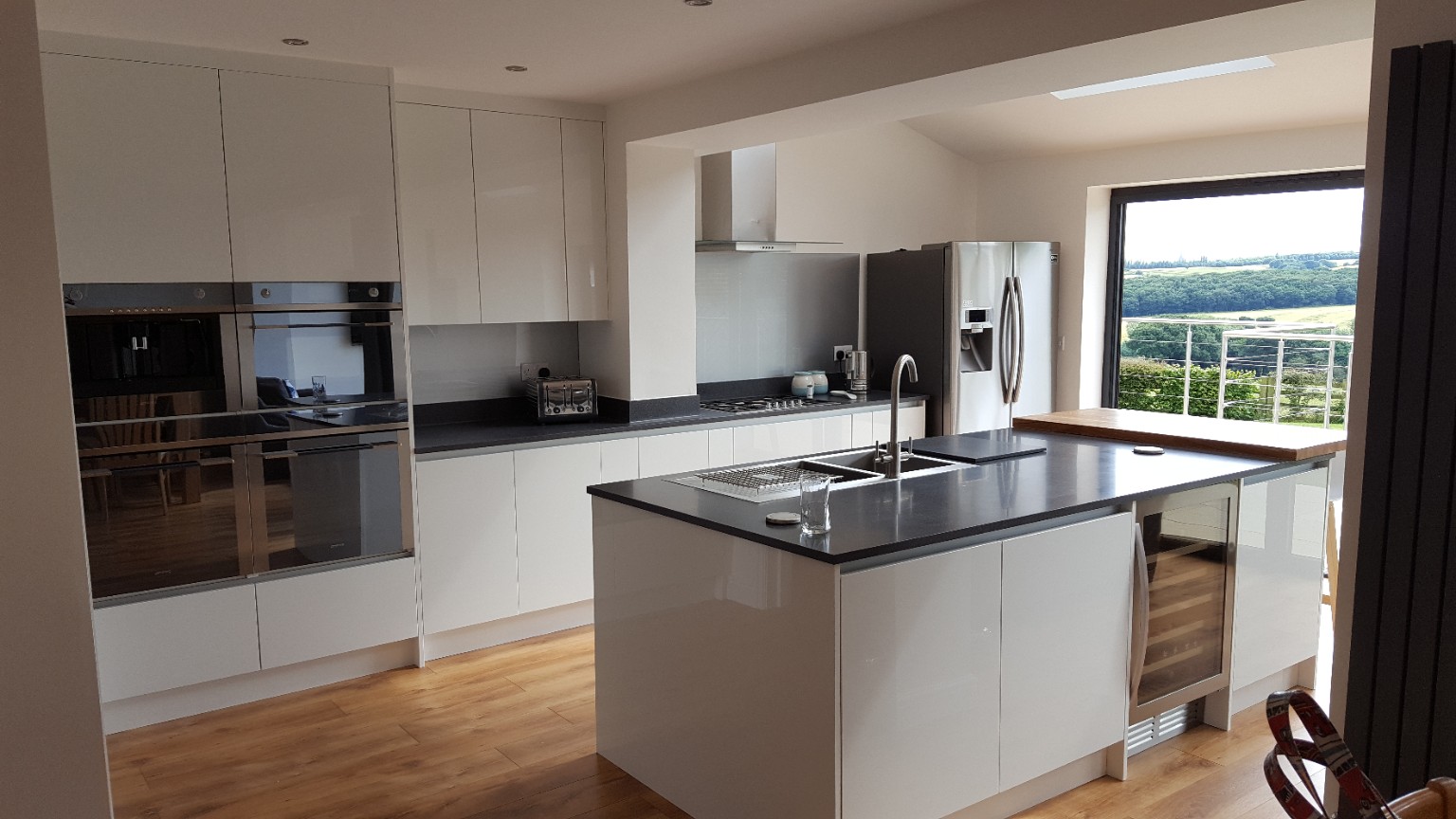 An island kitchen with integrated appliances and generous storage. Fitted by RCB.